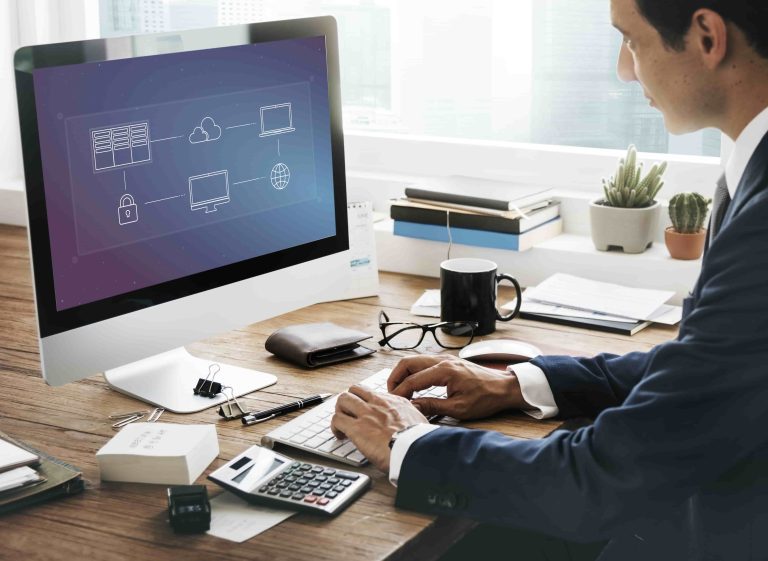 Persona trabajando en respaldo de base de datos con diagrama de nube en pantalla