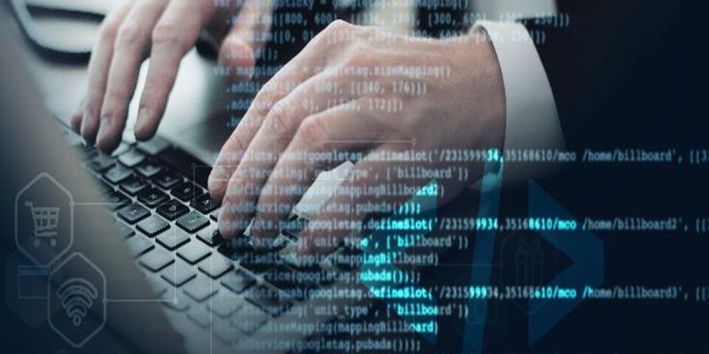 Manos de un experto en ciberseguridad escribiendo en un ordenador portátil con código y gráficos superpuestos